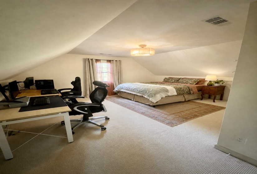 Carpeted bedroom with sloped ceilings