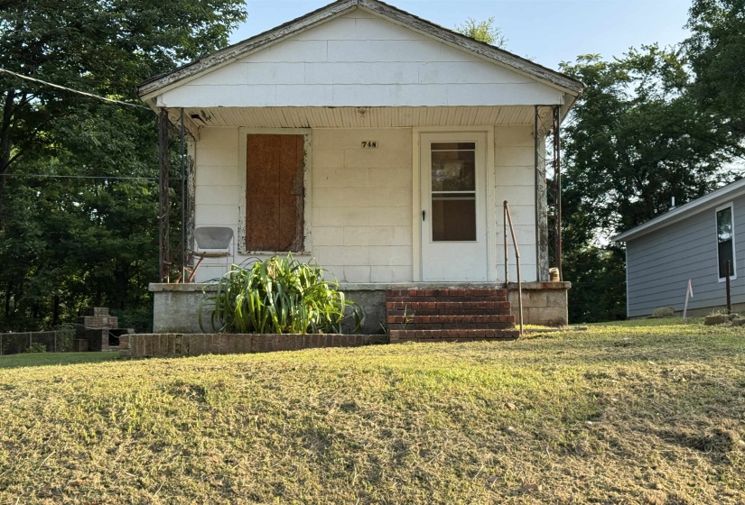 Single-story structure with a covered porch and brick stairs