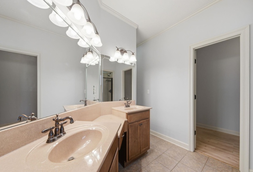 Dual vanity featuring integrated sinks, bronze-finish fixtures, and light-toned countertops
