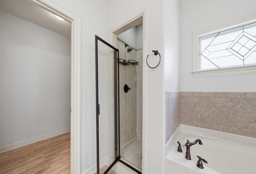 Bathroom featuring a corner jetted tub with decorative tile surround and bronze-finish fixtures
