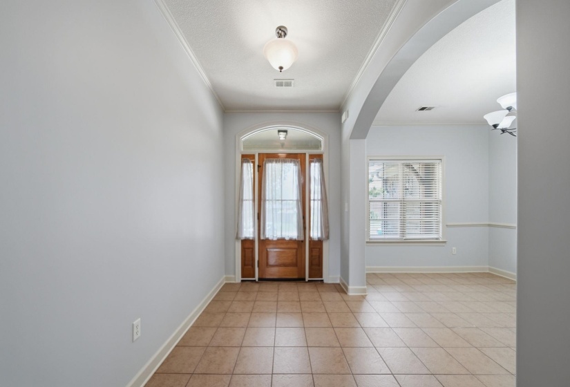 Entryway featuring a wood-panel door with sidelights, transom window, and tile flooring