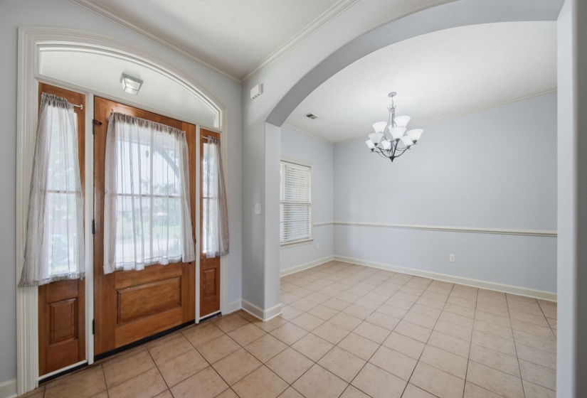 Foyer entry with a wood-paneled door, sidelights, and a transom window