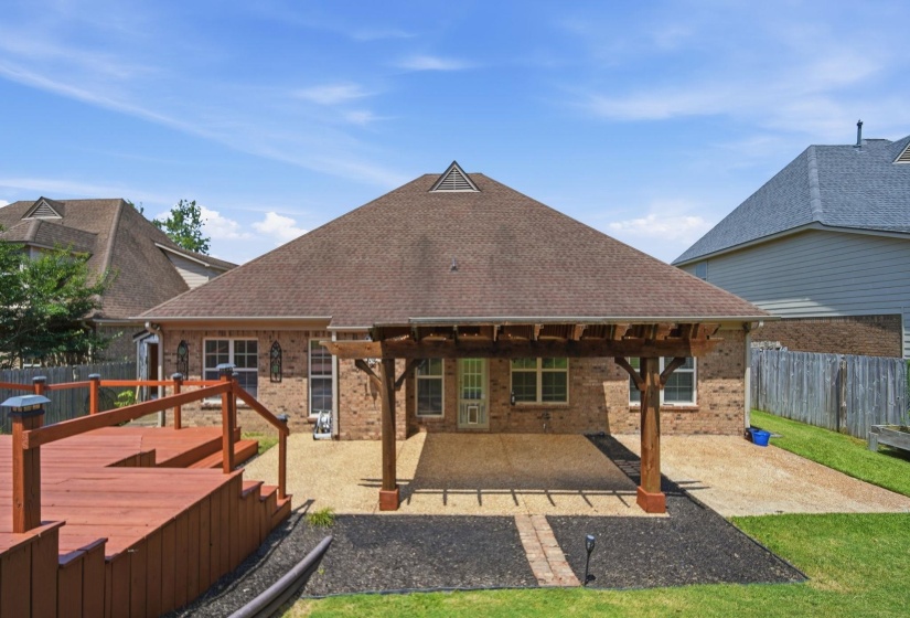 Expansive backyard featuring a multi-level wood-deck, a brick exterior, a covered patio with a wood pergola.