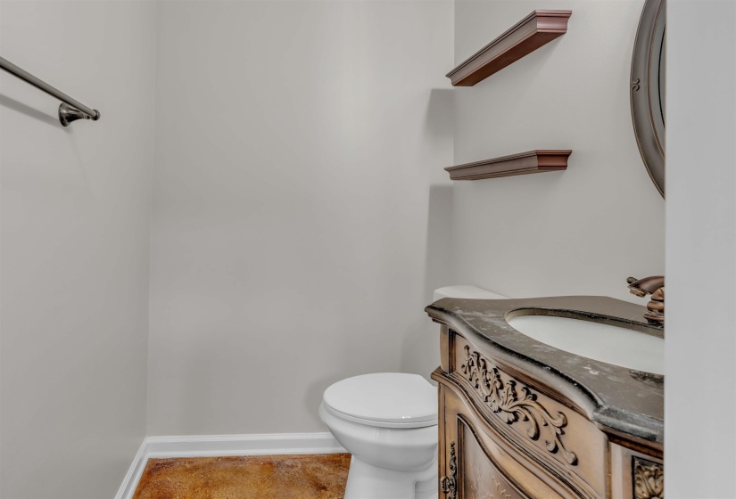 Vanity with an integrated sink, ornamental wood-finish cabinetry, and a dark countertop