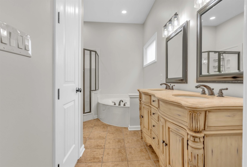 Bathroom featuring a double vanity with two undermount sinks, bronze faucets, and framed mirrors