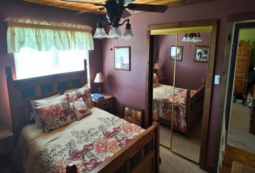 Room with wood-finish ceiling, ceiling fan, and window with blinds