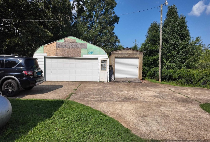 Concrete driveway offering parking and access to two separate detached garages