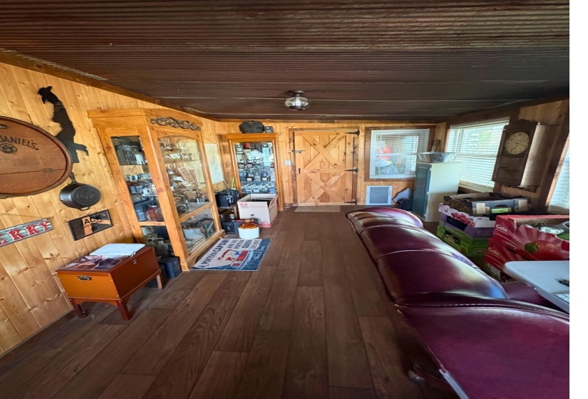 Wood-finish flooring with plank-style wall paneling and a corrugated metal ceiling