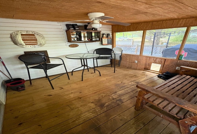 Screened porch featuring wood-finish flooring, wood-paneled ceiling, and a ceiling fan