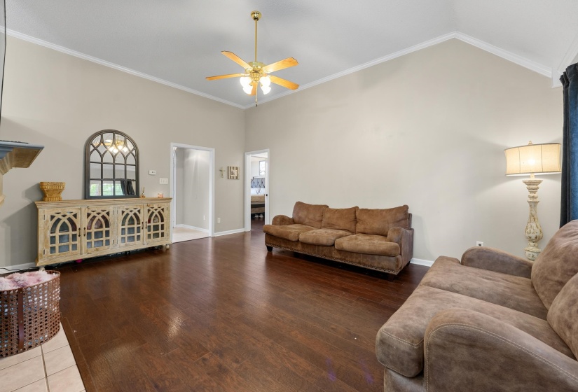 Spacious living area featuring high vaulted ceilings, wood-finish flooring, and a ceiling fan with integrated lighting