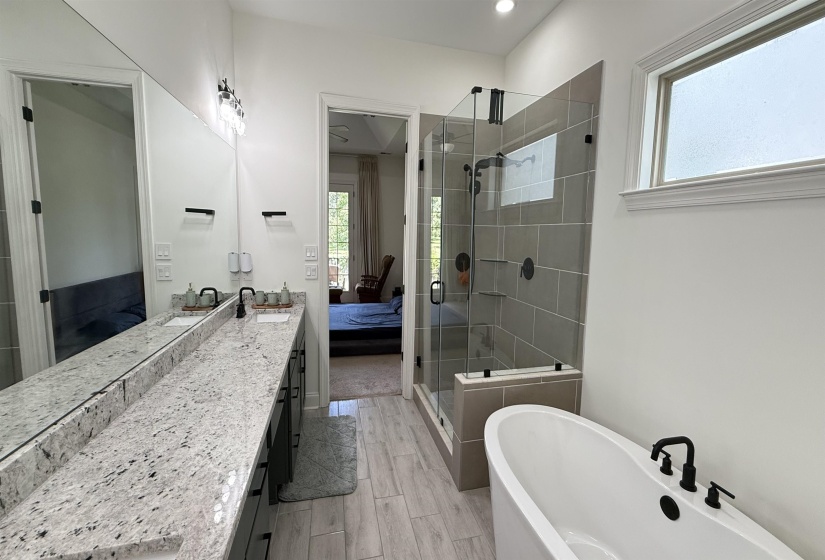 Ensuite bathroom with a shower stall, a freestanding bath, vanity, wood finish floors, and recessed lighting
