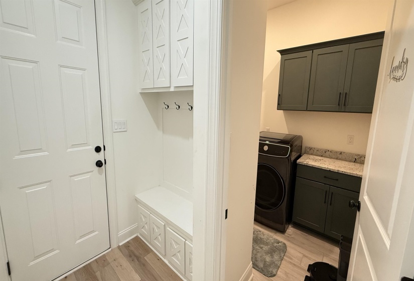 Laundry room with cabinet space, light wood-type flooring, and washer / dryer
