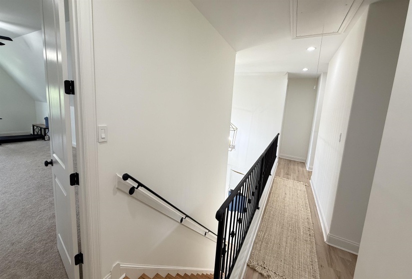 Hallway featuring an upstairs landing, attic access, recessed lighting, and light carpet
