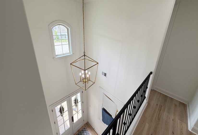 Stairs featuring a chandelier, wood finished floors, and a towering ceiling