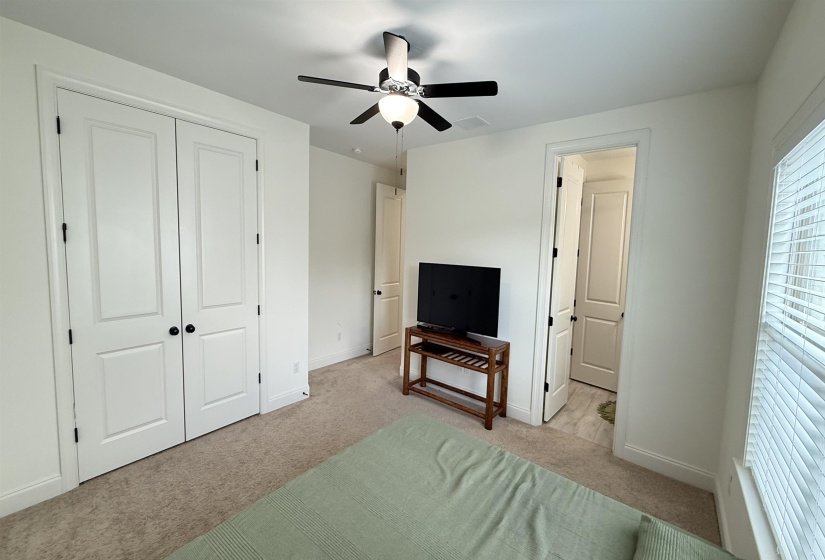 Bedroom featuring light carpet, a closet, and ceiling fan