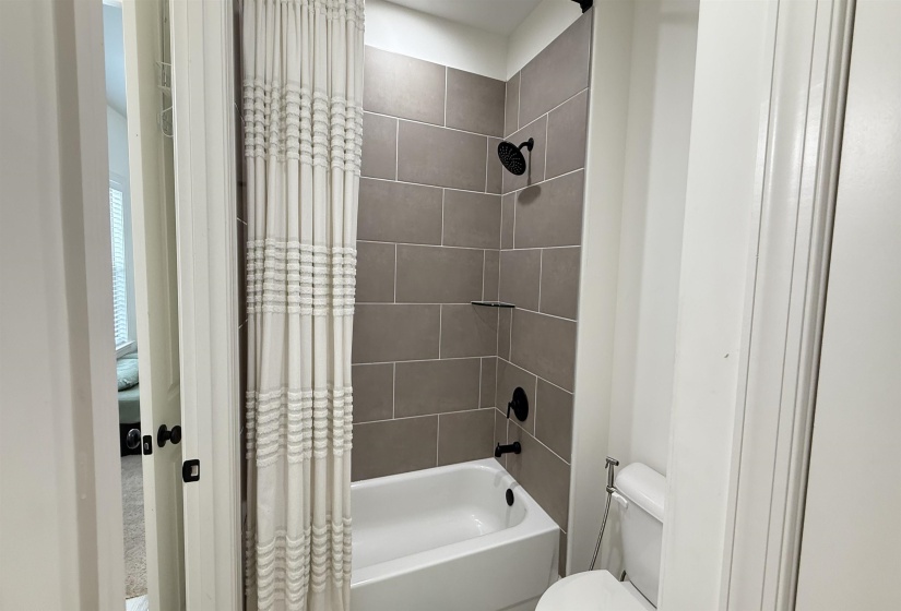 Full bath featuring shower / bath combination with curtain and toilet