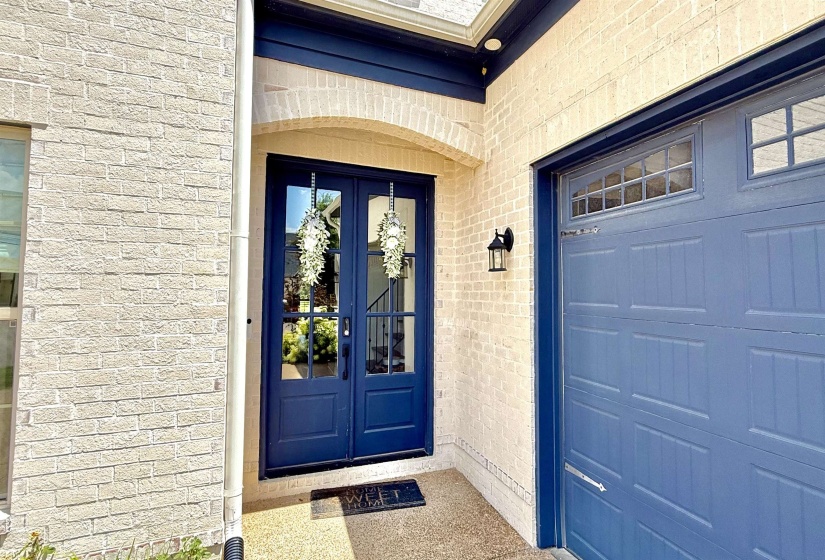 Property entrance featuring brick siding, french doors, and a garage