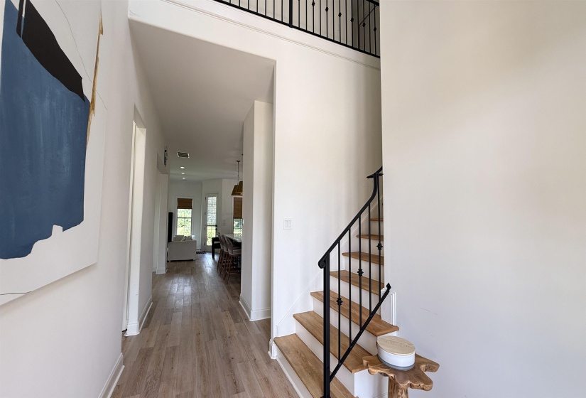 Staircase with wood finished floors and baseboards