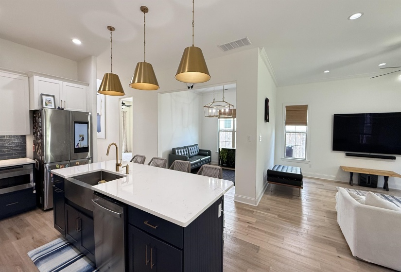 Kitchen with open floor plan, stainless steel appliances, light countertops, light wood-style flooring, and recessed lighting