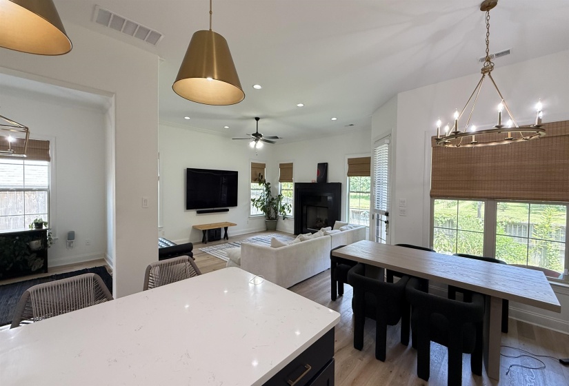 Kitchen with a chandelier, light wood finished floors, a fireplace, ceiling fan, and recessed lighting
