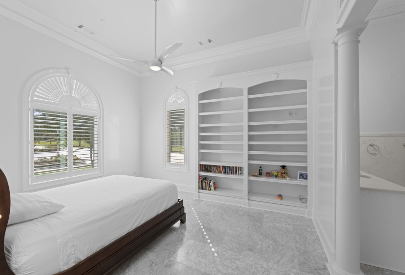 Bedroom featuring ornamental molding, a ceiling fan, and decorative columns