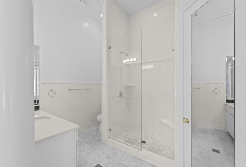 Full bath featuring tile walls, a wainscoted wall, vanity, and a stall shower