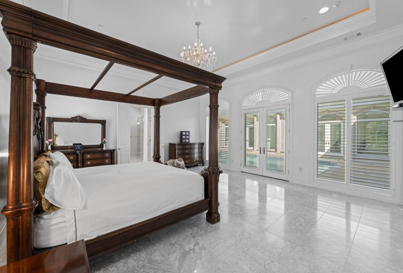 Bedroom with french doors, access to exterior, a chandelier, ensuite bathroom, and crown molding