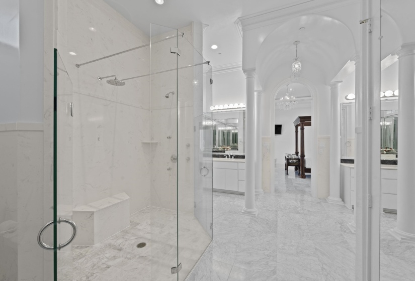 Full bath featuring ornate columns, a marble finish shower, a chandelier, vanity, and marble finish floors