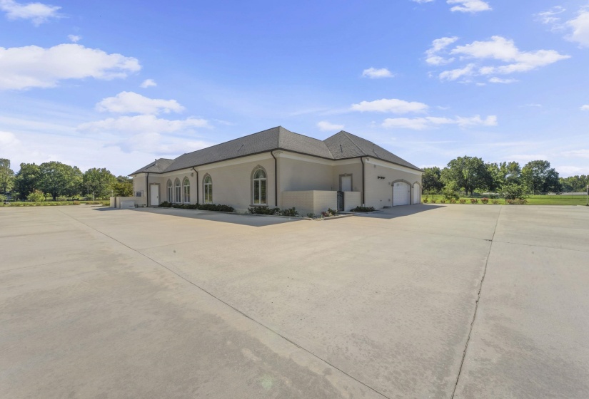 View of side of property featuring stucco siding, concrete driveway, and a garage