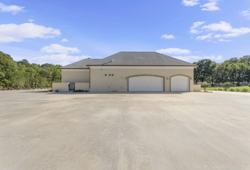 View of side of property with stucco siding, an attached garage, and concrete driveway