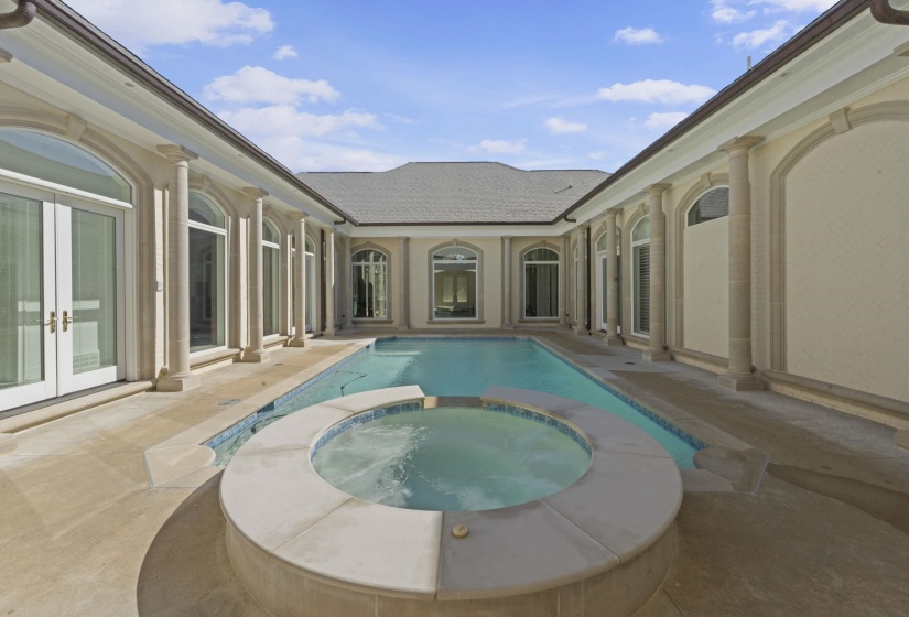 View of swimming pool featuring french doors, a pool with connected hot tub, and a patio area