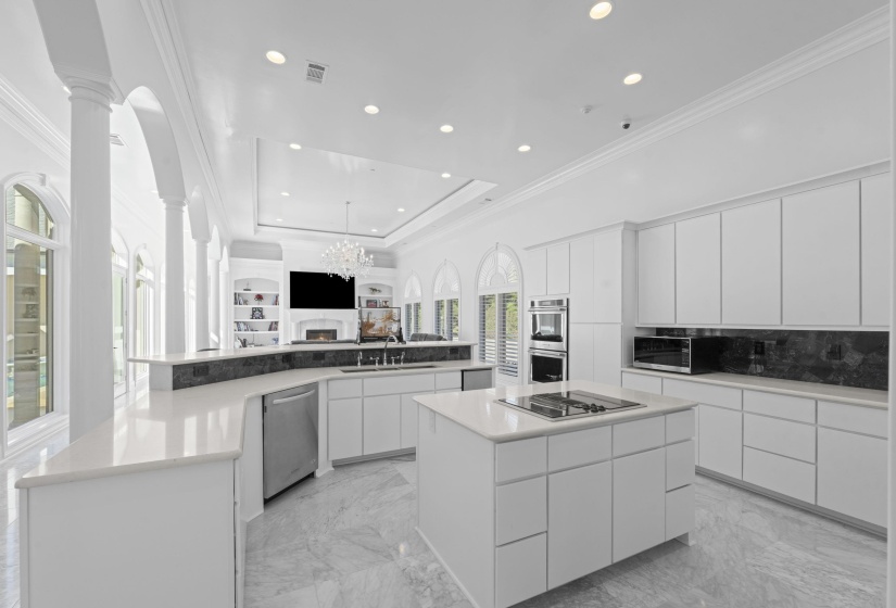 Kitchen with crown molding, white cabinetry, light marble finish floors, modern cabinets, and open floor plan
