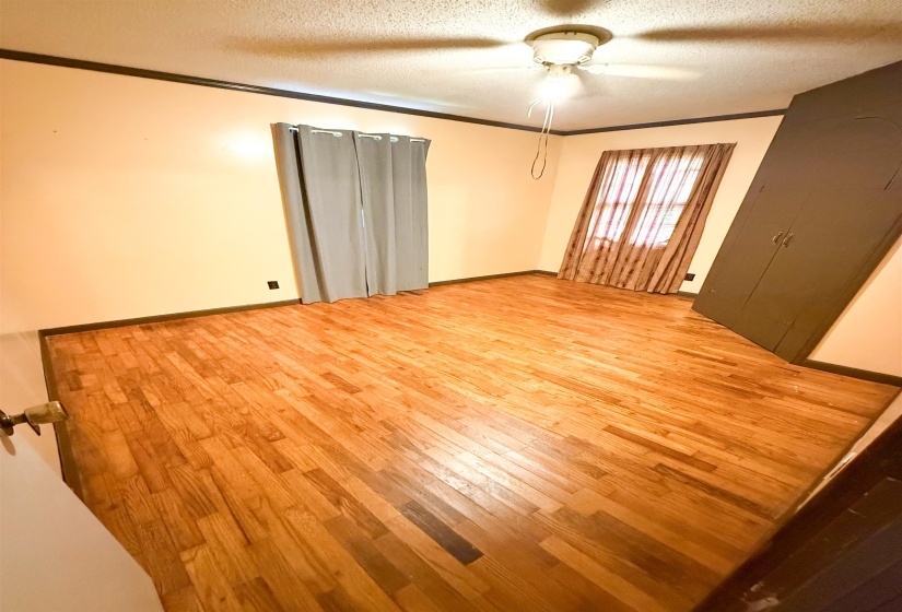 Hardwood flooring throughout, featuring a ceiling-mounted light fixture with fan functionality