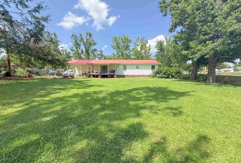 Expansive green lawn with mature trees providing natural shading