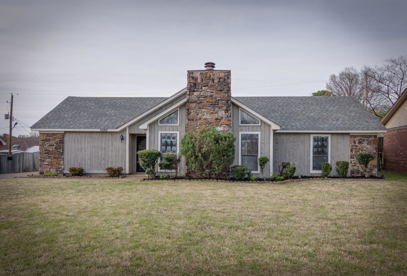 Stone and siding exterior with an imposing stone chimney
