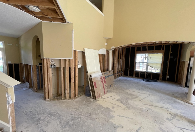 Two-story interior space featuring an arched doorway and a large window