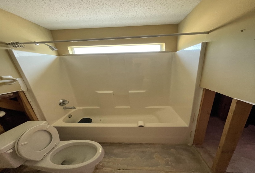 Tub and shower combination unit with an integrated shelf