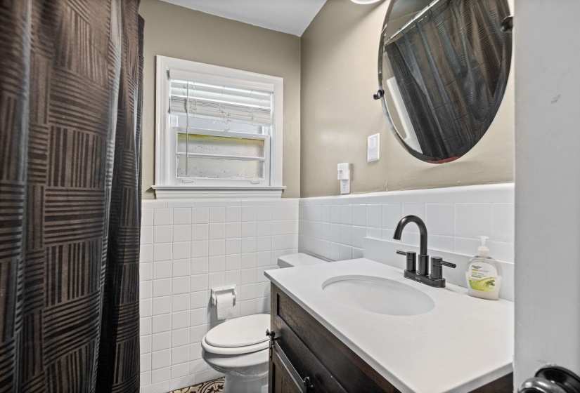 Modern bathroom vanity with a white countertop, undermount sink, and matte black faucet