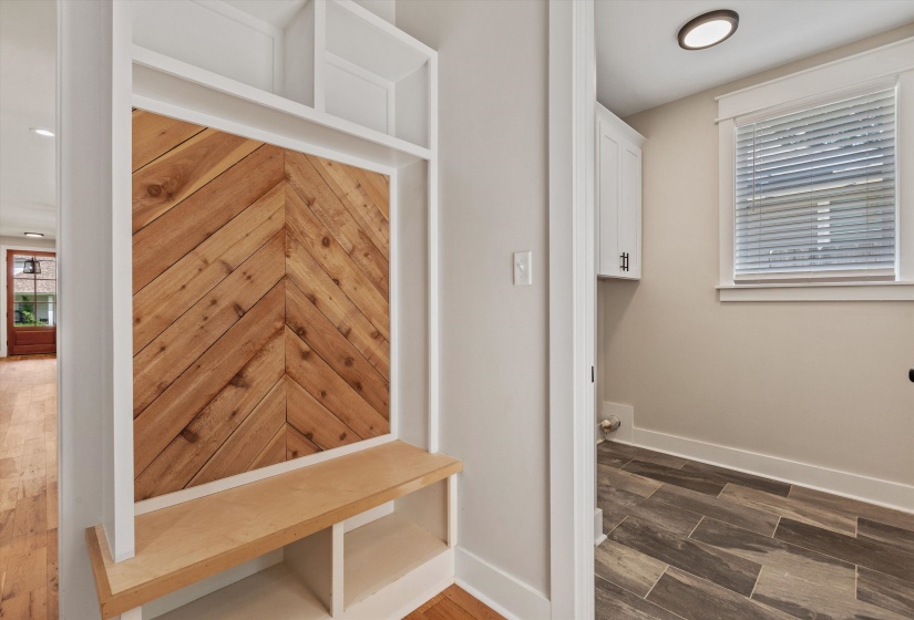 Built-in entryway storage with wood-finish chevron accent paneling and an integrated bench