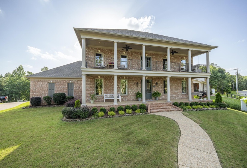 Brick facade residence featuring a two-story covered porch with white columns