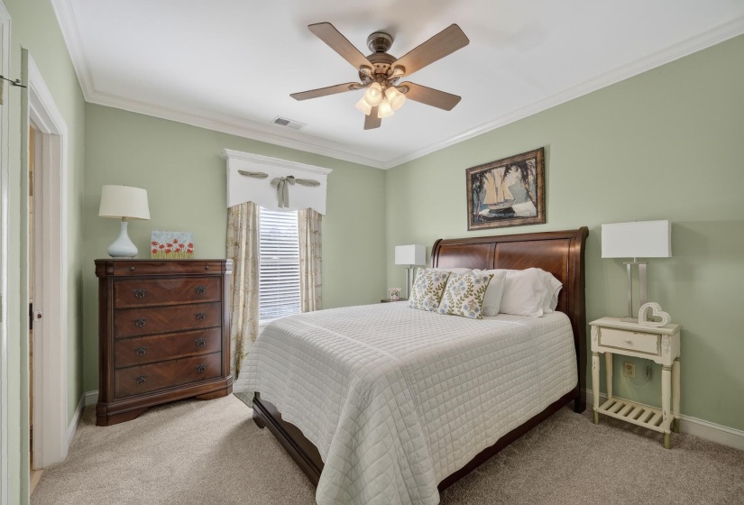 Bedroom featuring light green walls and neutral carpeting