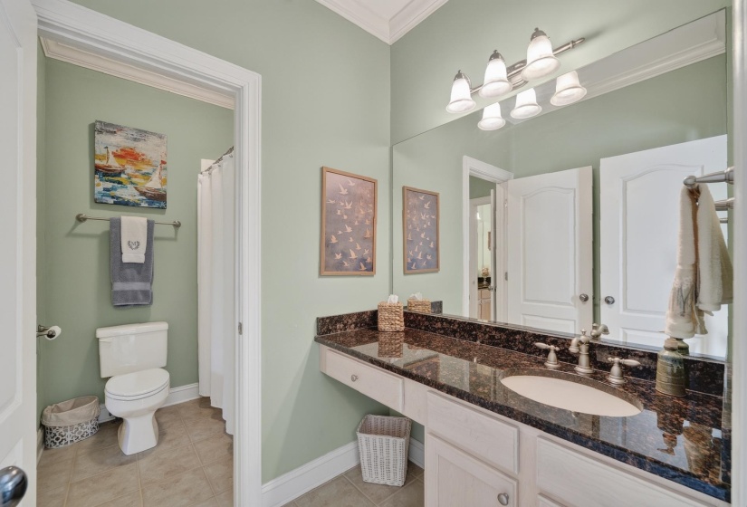 Bathroom vanity featuring a dark granite countertop with an undermount sink, white cabinetry, and brushed nickel fixtures