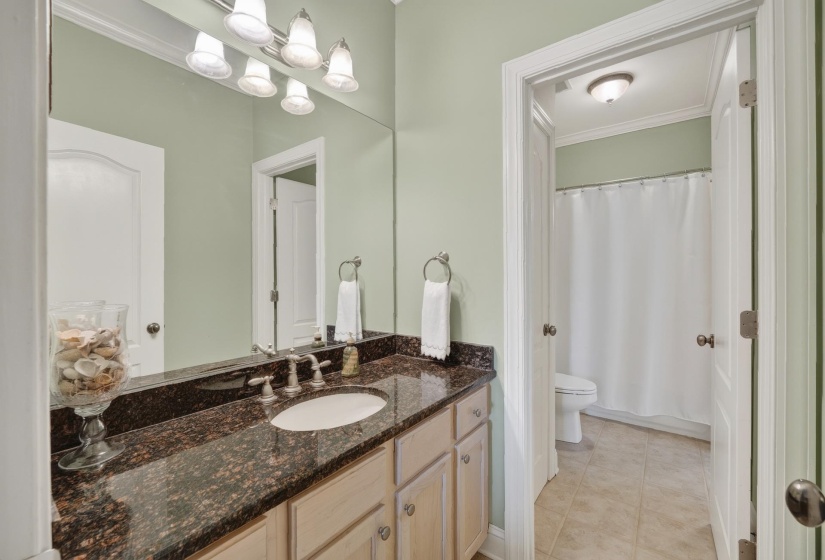Bathroom vanity featuring a polished granite countertop, undermount sink, and brushed nickel fixtures