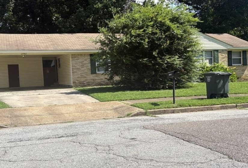 Ranch-style residence featuring a brick facade with light-colored siding, a covered carport, and a concrete driveway