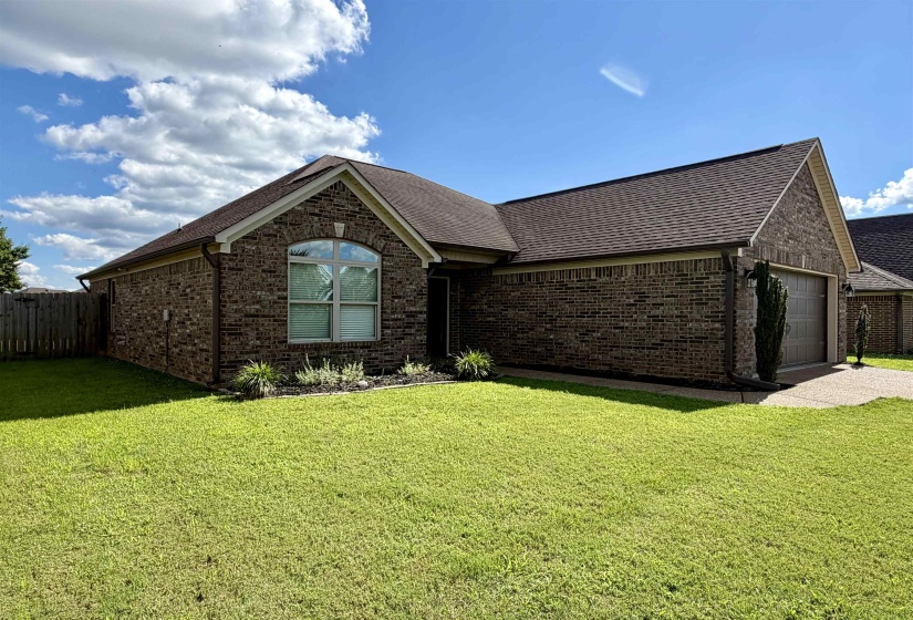 Brick exterior residence featuring a front-facing garage with a paved driveway