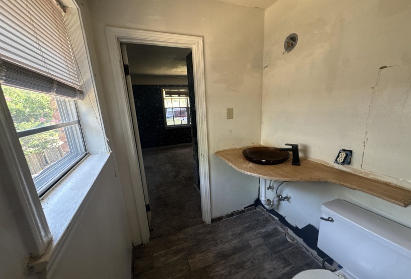 Bathroom featuring a floating wood-finish vanity with a vessel sink and a matte black faucet