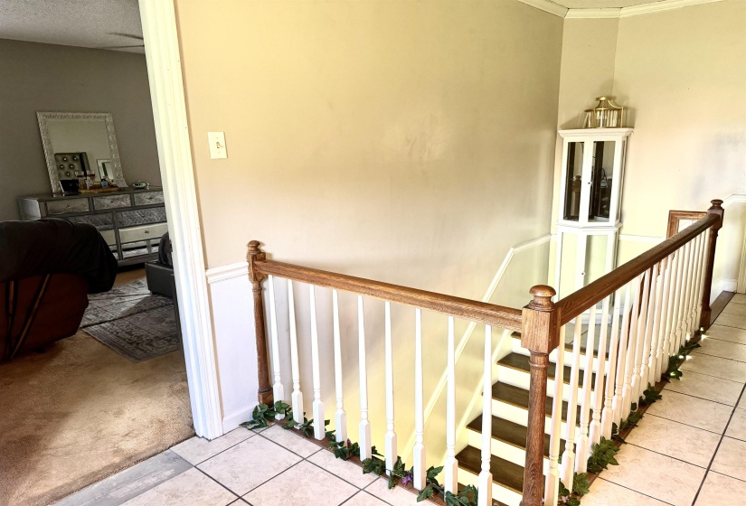 Staircase featuring wood-finish handrail with white balusters