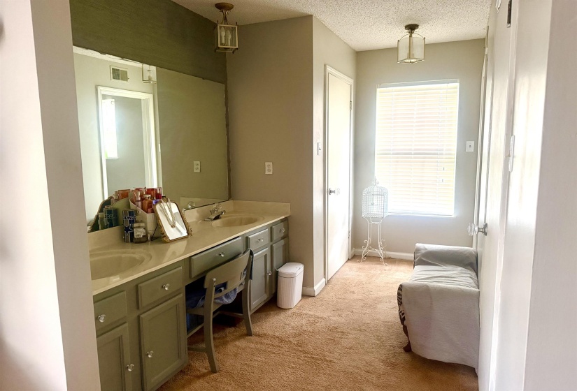 Double vanity with undermount sinks, expansive counter space, and integrated makeup area