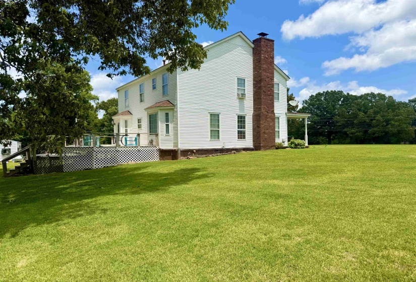 White siding exterior with a prominent brick chimney and multiple windows