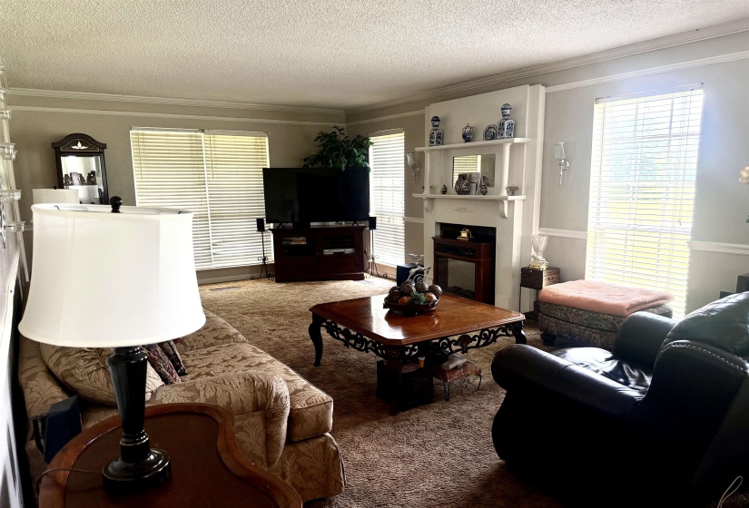 Expansive green acreage featuring a substantial mature tree, rolling topography, and dark-stained fencing